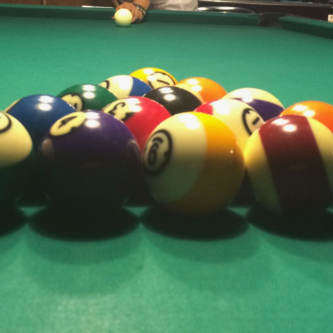 Billiards table with pool cue and balls, representing strategy and patience in building a creative business