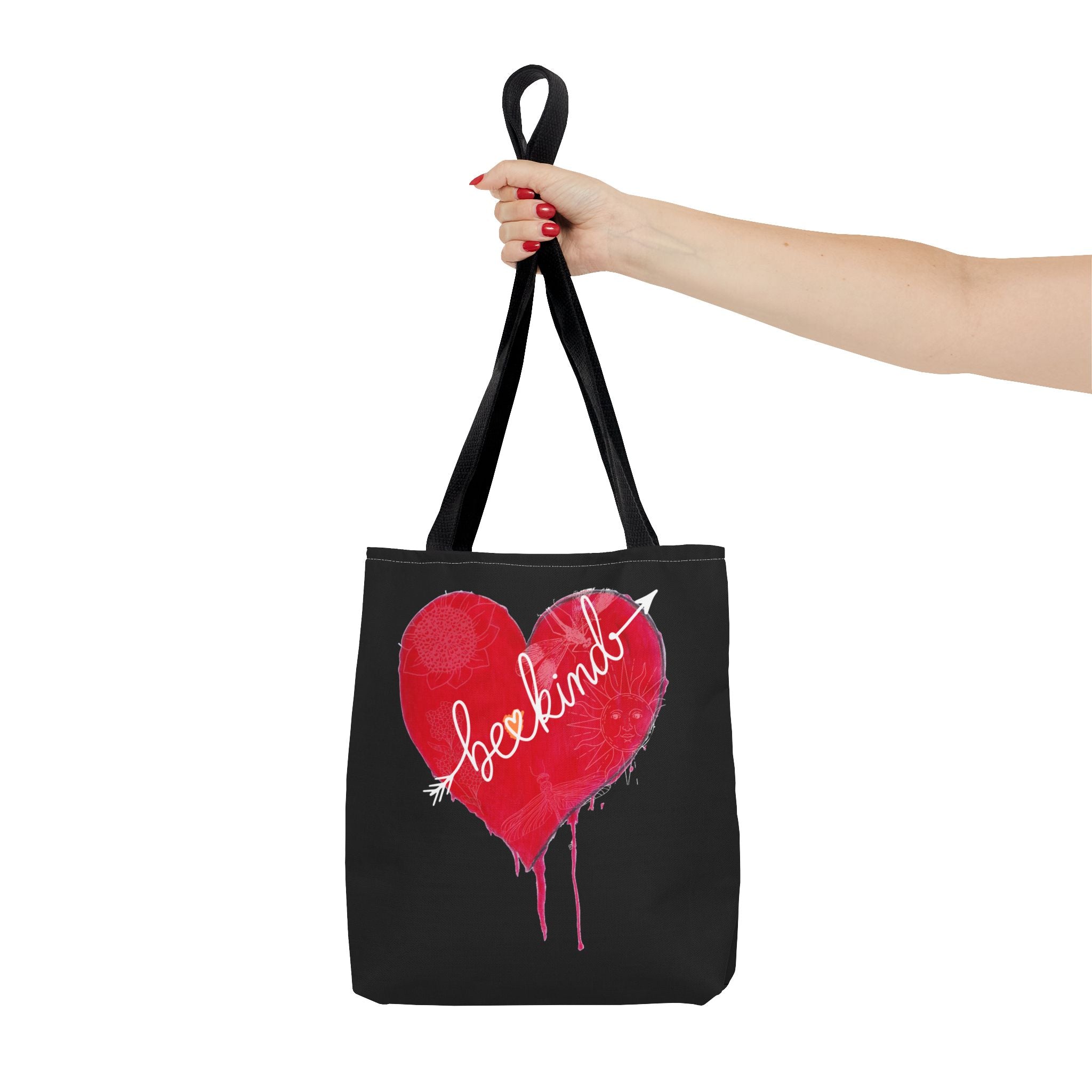 Black tote bag with a red heart and white text held by a hand on a white background