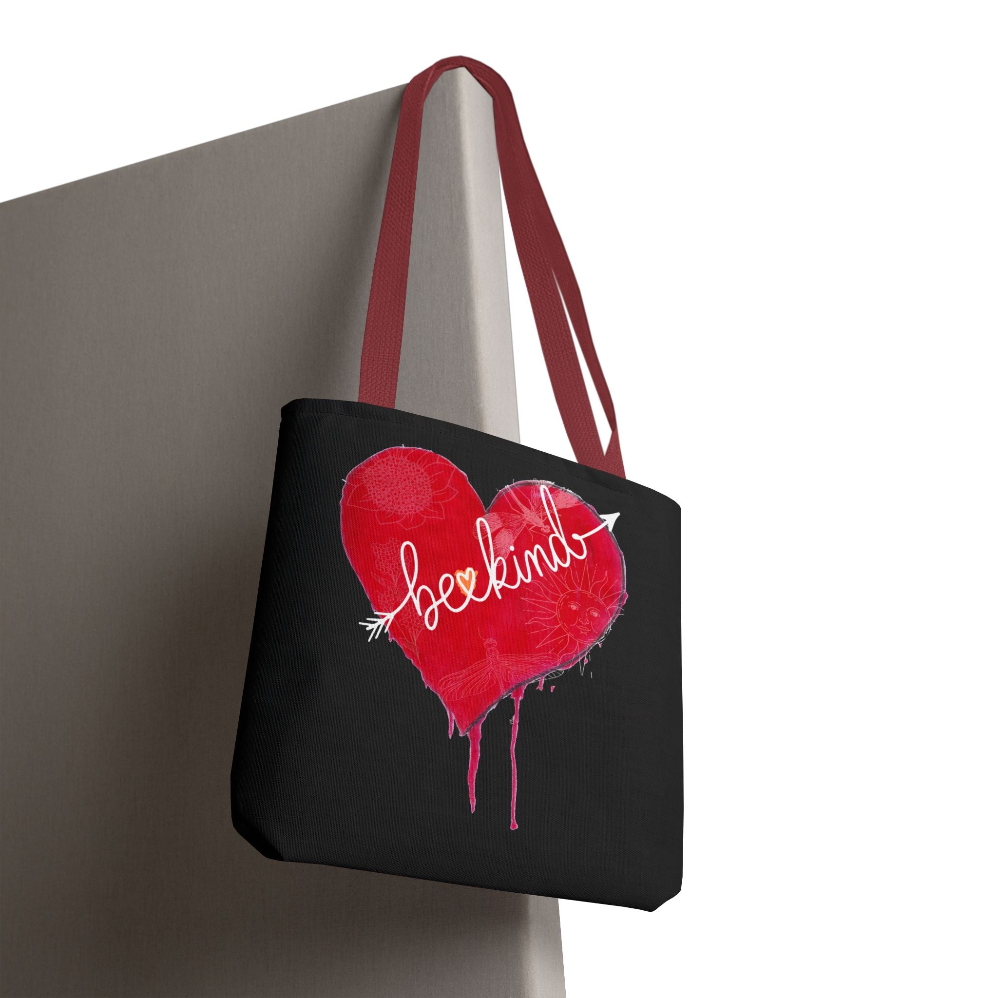 Black tote bag with a red heart and white text on a gray surface