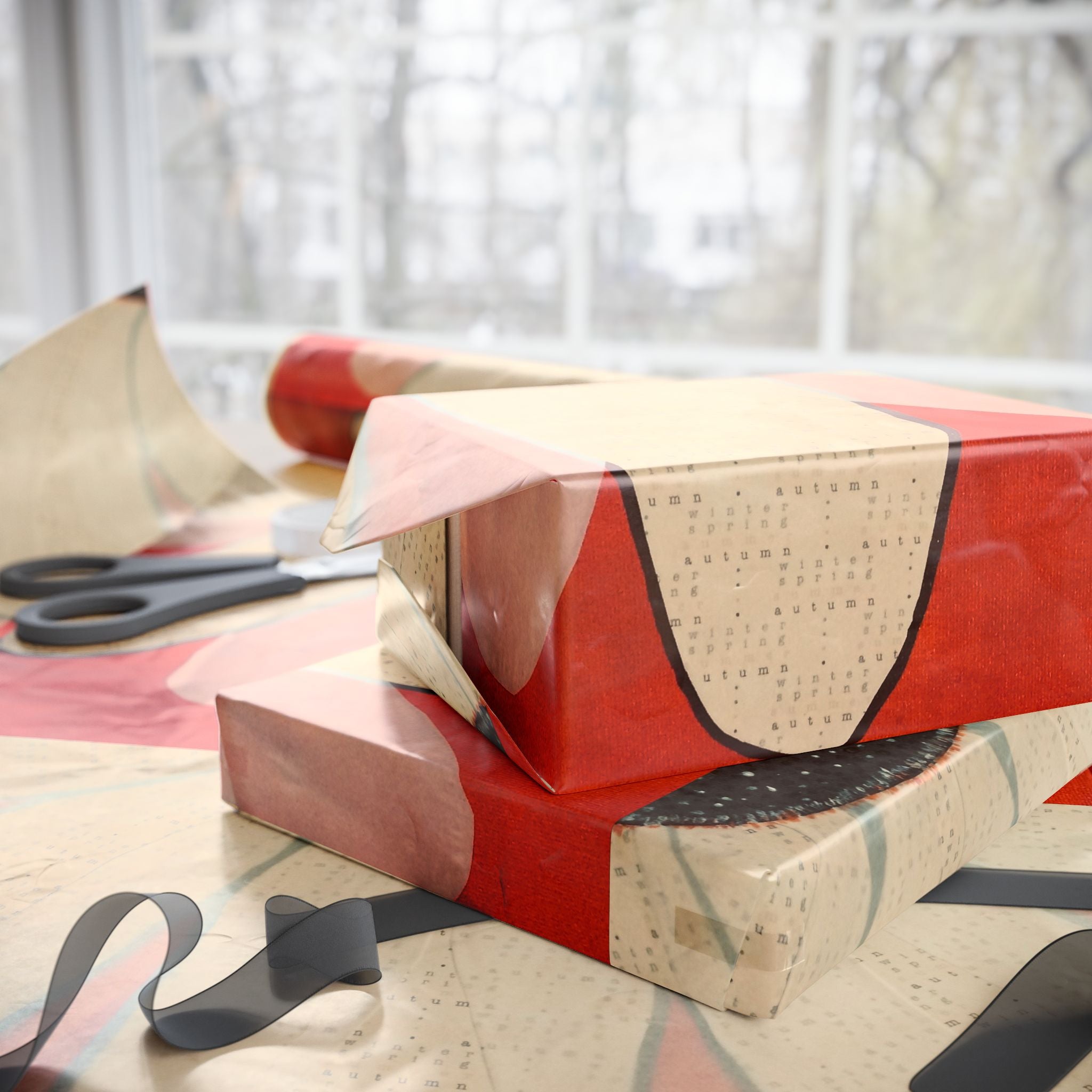 Gift boxes wrapped in red and beige paper with scissors on a light surface.
