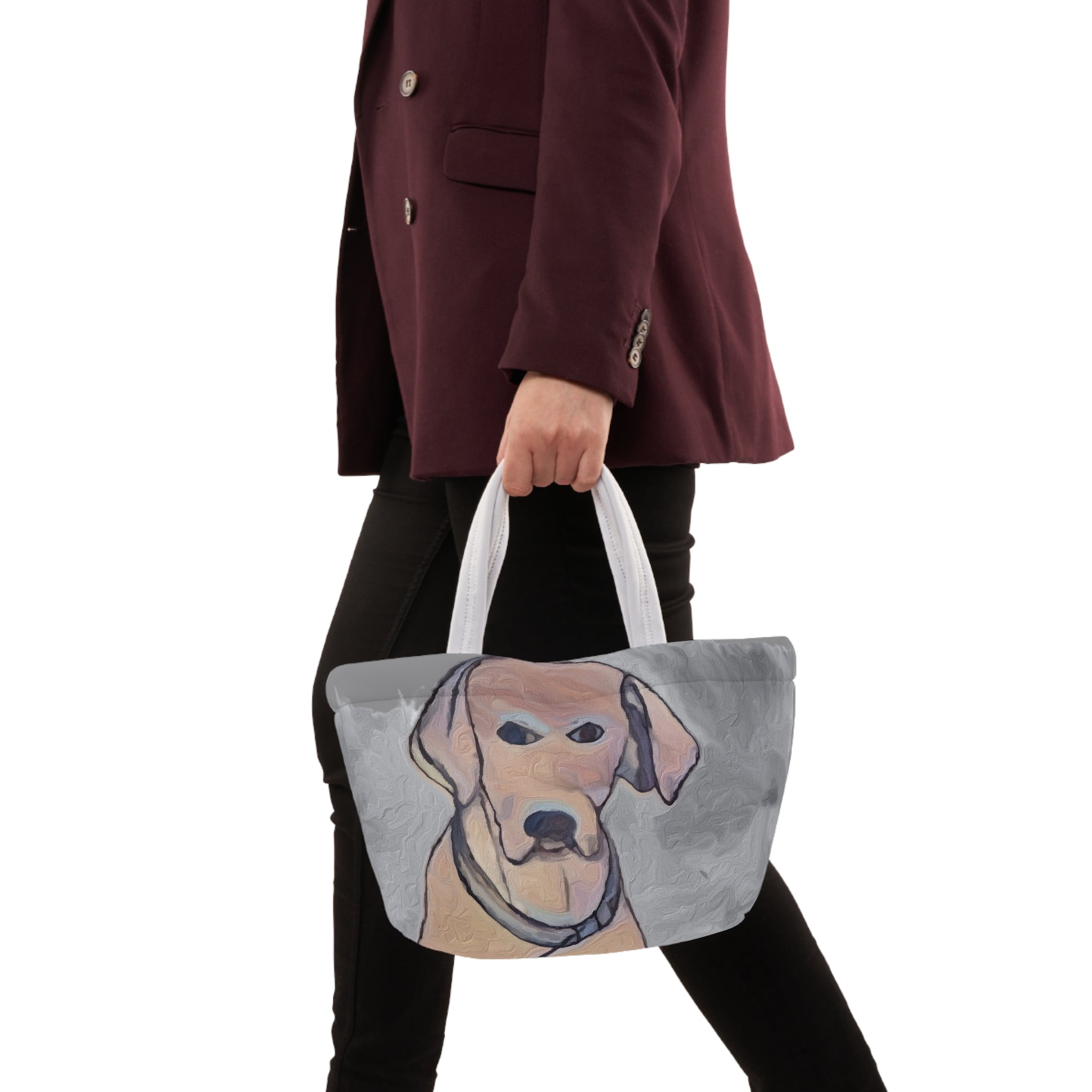 Person holding a handbag with a dog's face design on a white background