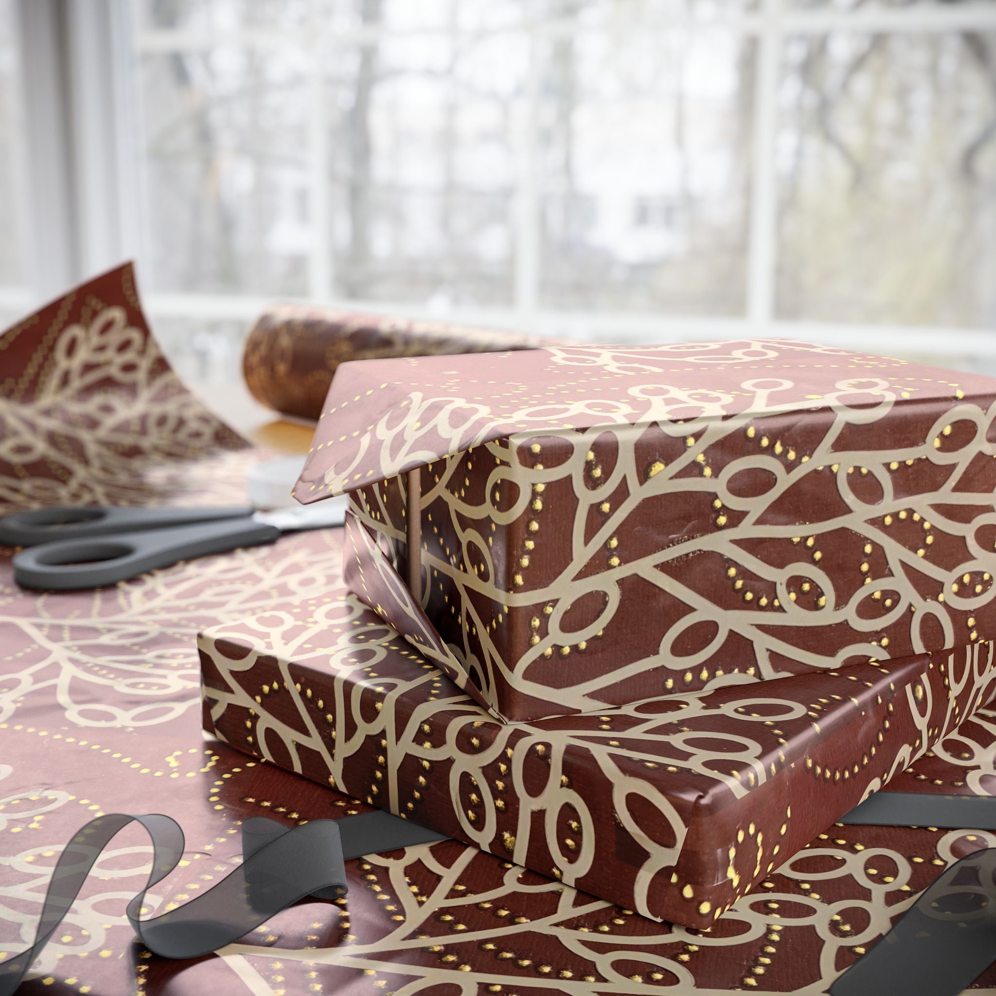 Gift boxes wrapped in brown paper with gold patterns on a table.