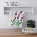 Decorative towel with lavender plant design hanging on a white shelf in a kitchen setting.