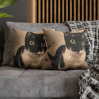 Two cat-themed pillows on a gray sofa with a wooden panel background.