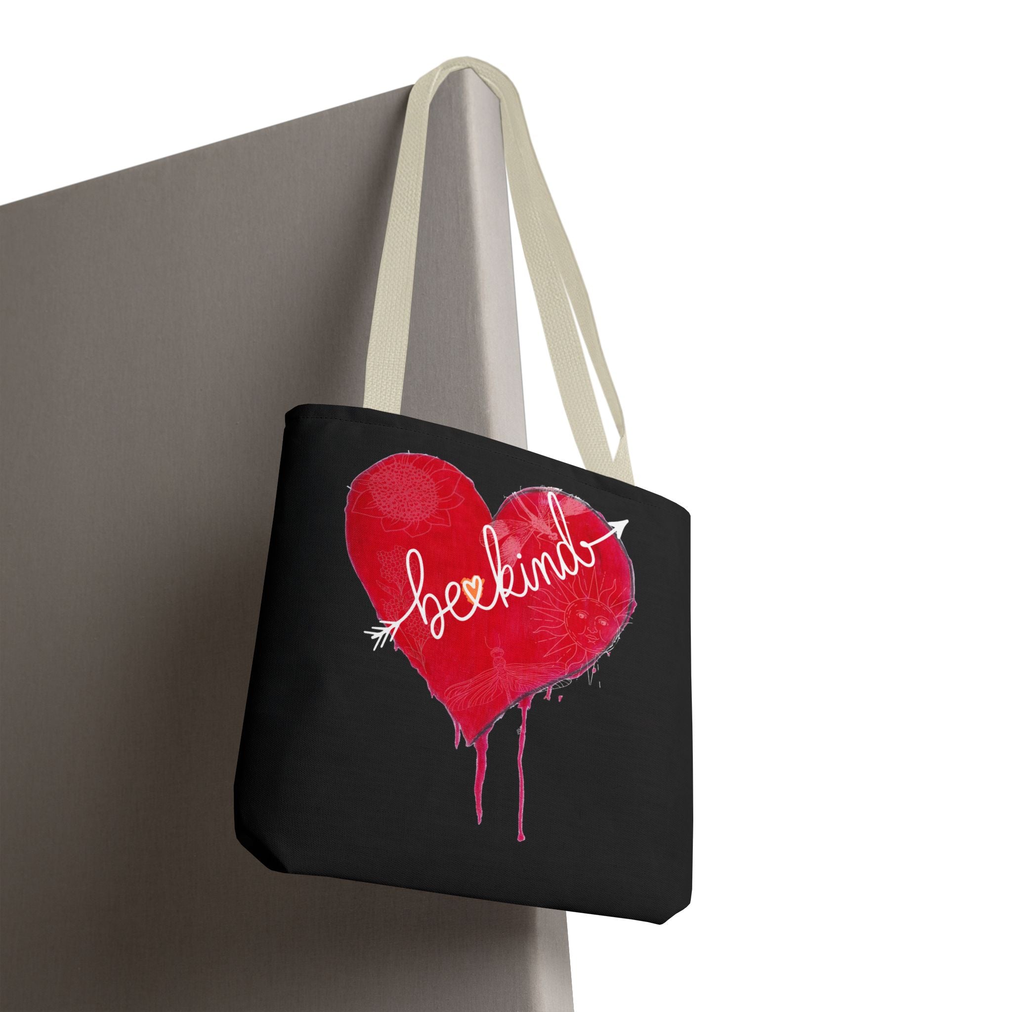Black tote bag with a red heart and white text on a gray surface