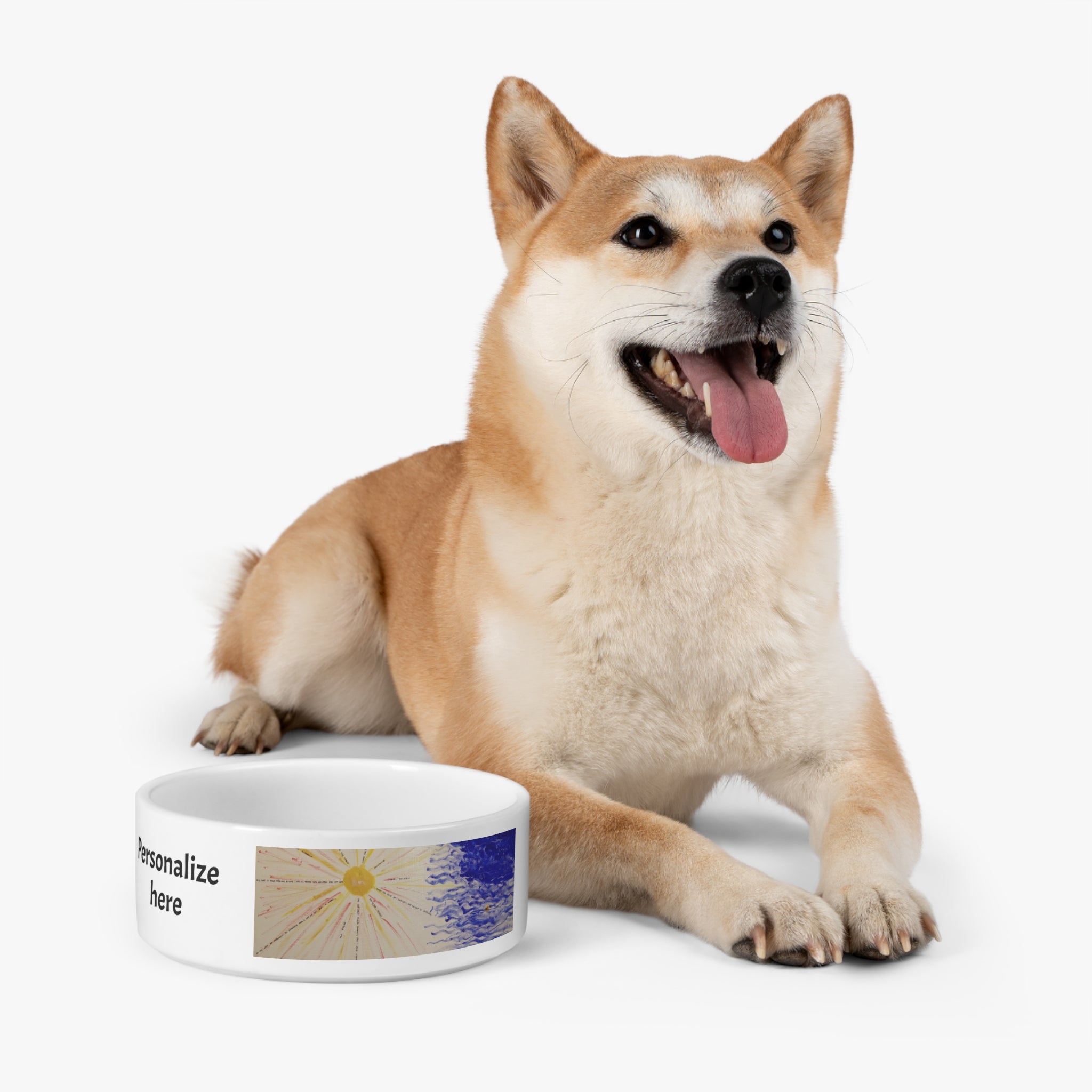 Dog sitting next to a personalized pet bowl on a white background