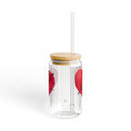 Clear tumbler with red heart designs, wooden lid, and straw on a white background
