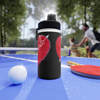 Black water bottle with red design on a ping pong table with people playing in the background