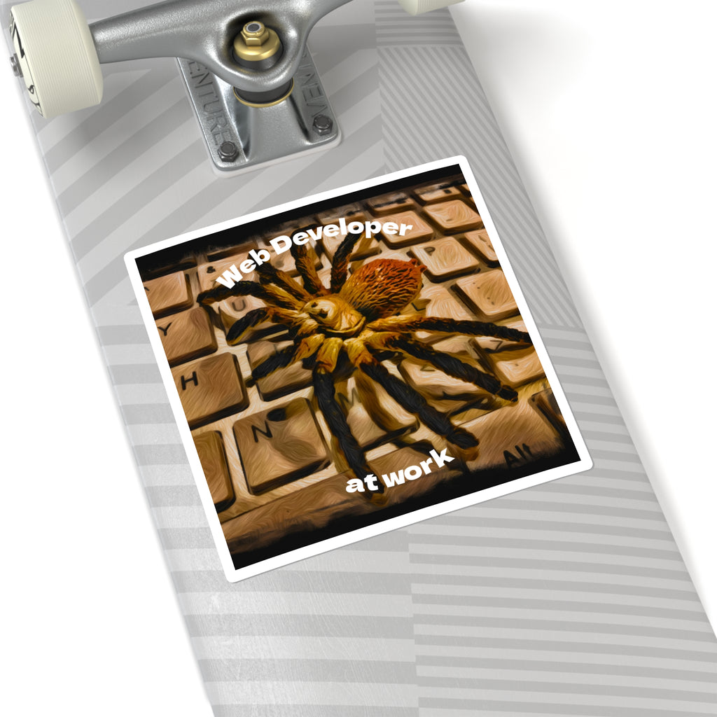 Sticker with a spider on a keyboard and text 'Web Developer at work' on a skateboard deck.