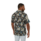 A man wearing a short-sleeve button-up shirt with a large white daisy floral print on a dark gray background, shown from the back against a plain white studio background.