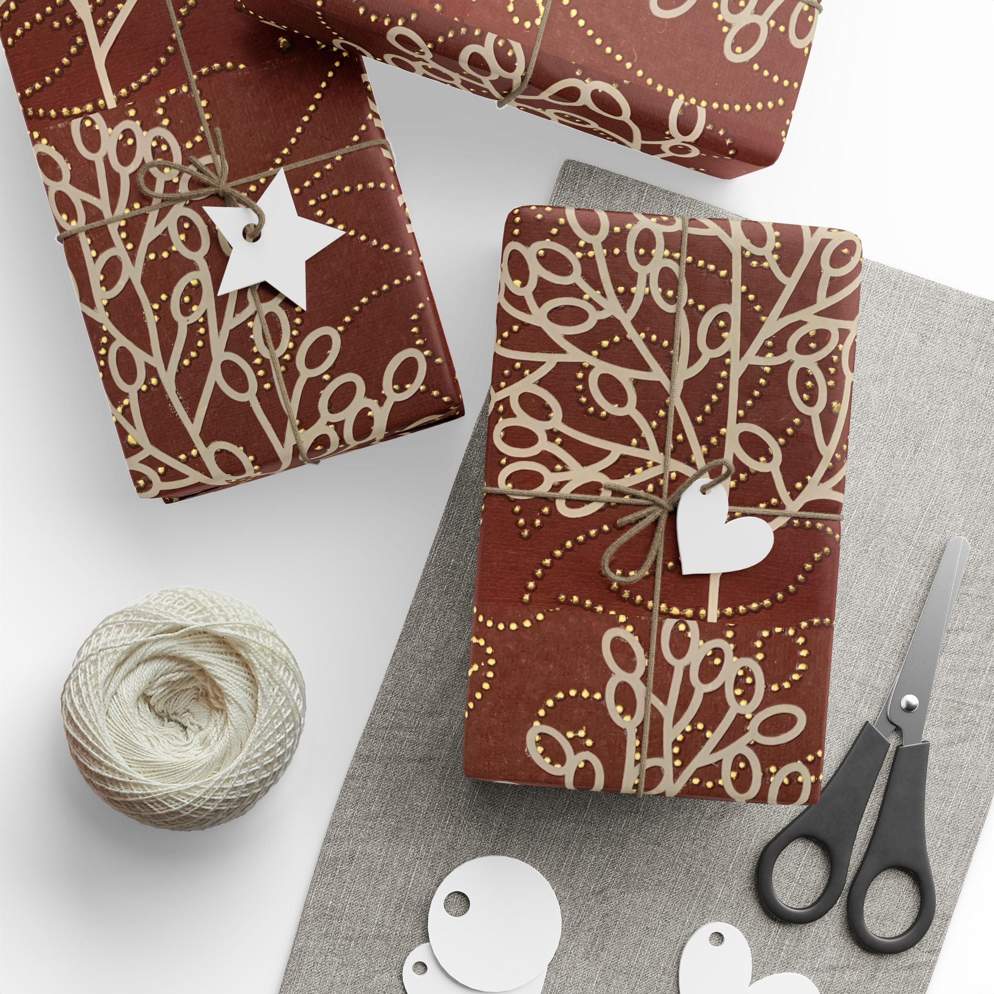 Gift-wrapped items with decorative ribbons, tags, and scissors on a white surface