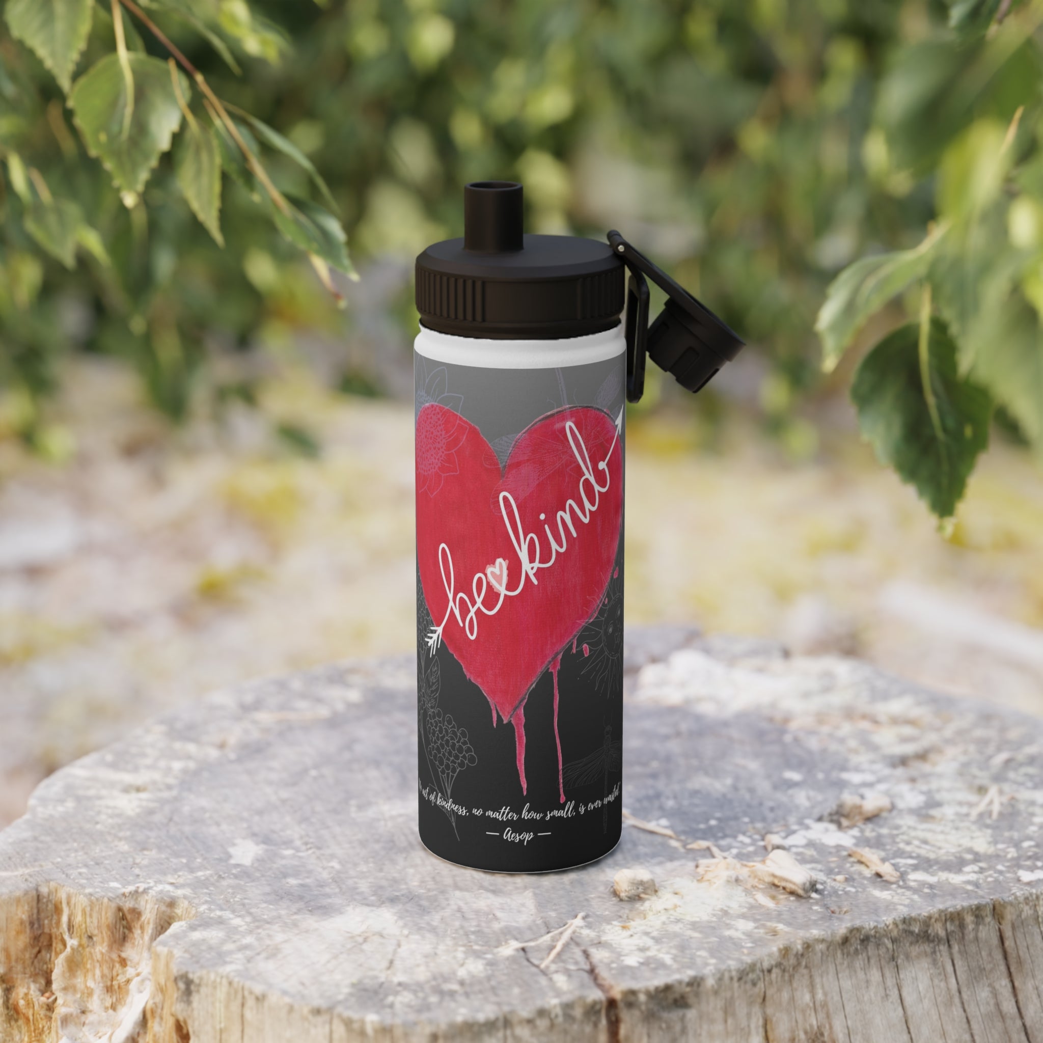 Water bottle with red heart and white text on a natural background