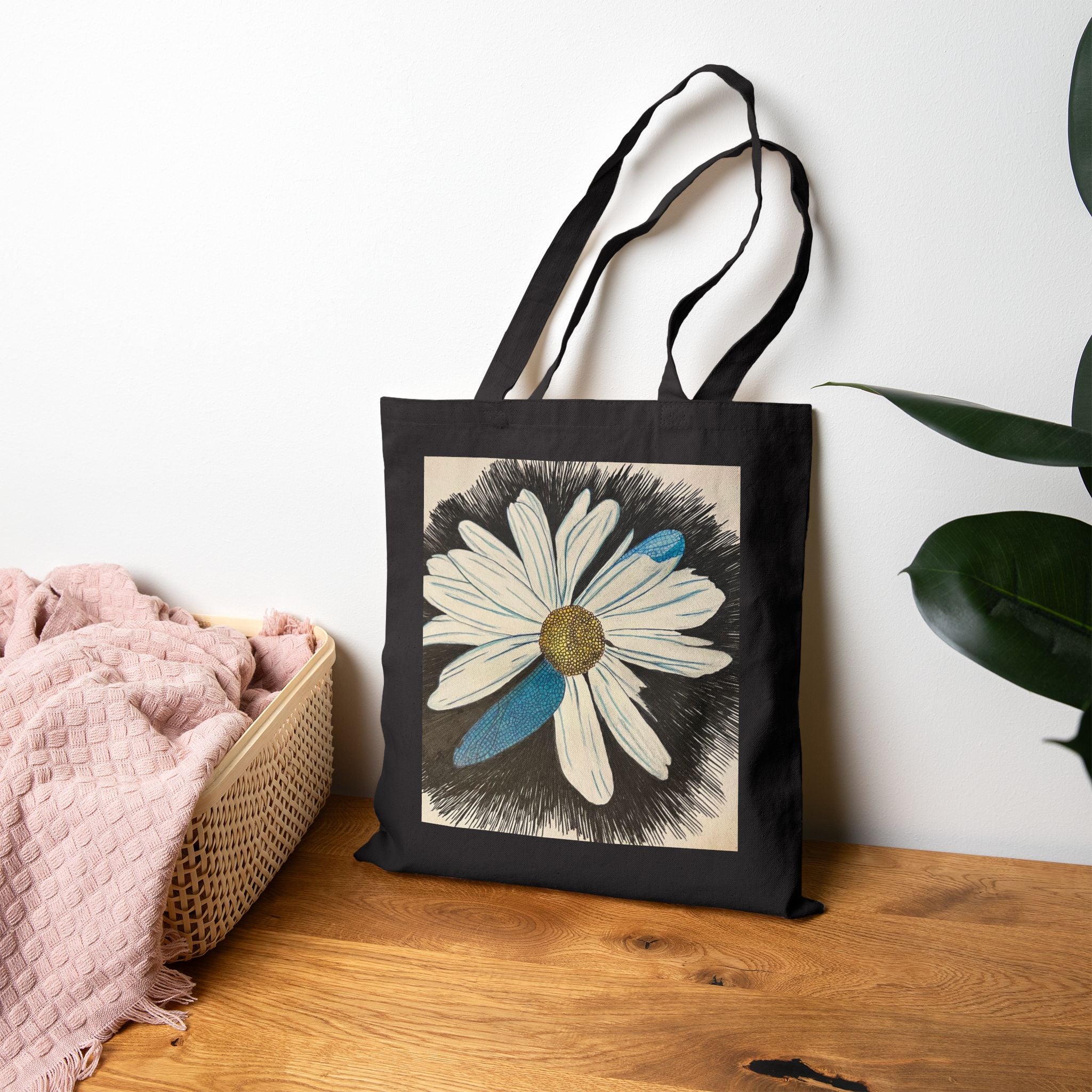 Black tote bag with a floral design on a wooden surface