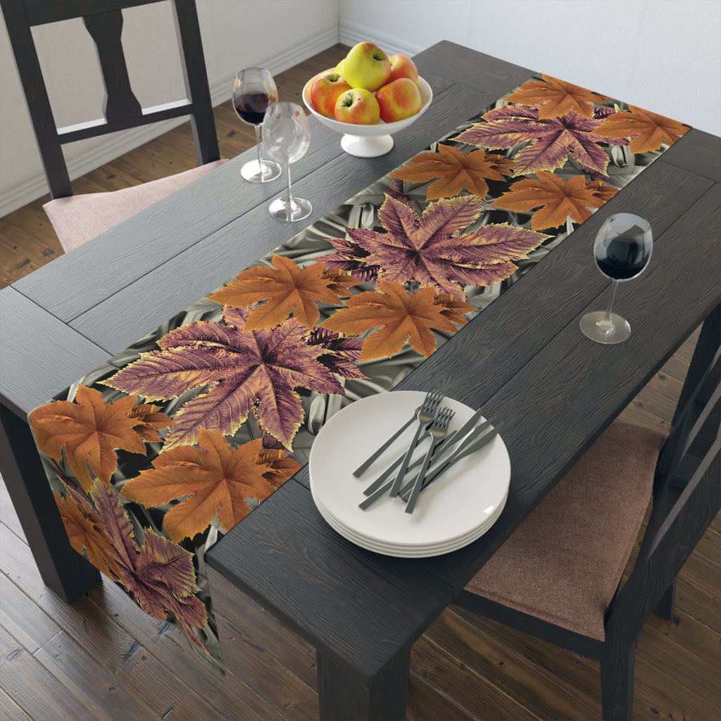 Dining table set with a leaf-patterned table runner, plates, and glasses.