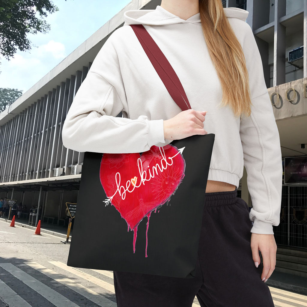 Person holding a black tote bag with a red heart design and 'beckin' logo.