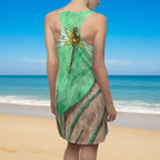 Green and brown dress with dragonfly design worn by a model at a beach