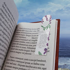 Open book with a floral bookmark against a scenic background