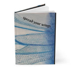 Book with blue and white design and text 'spread your wings' on a white background