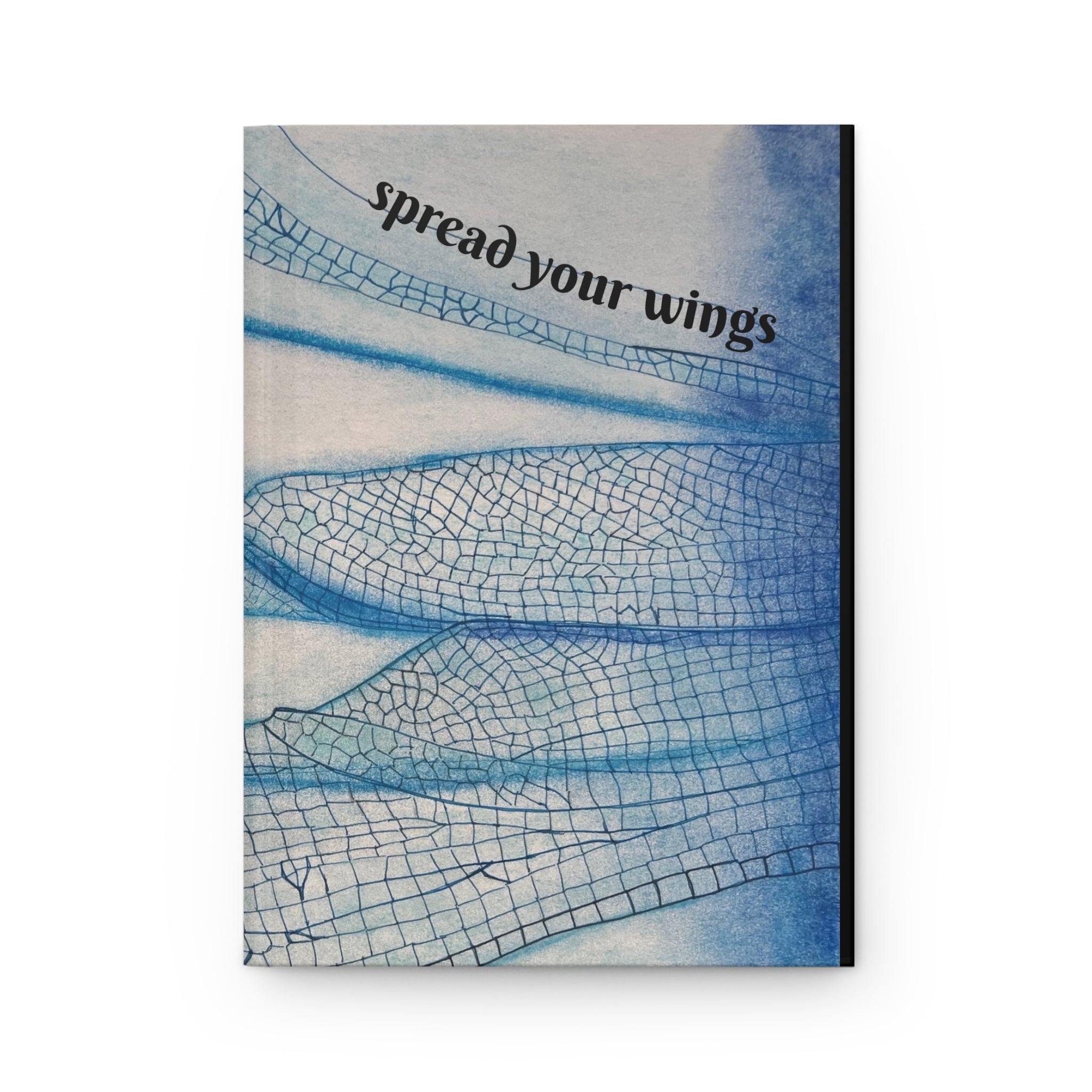 Notebook cover with blue butterfly wings and text 'spread your wings' on a white background