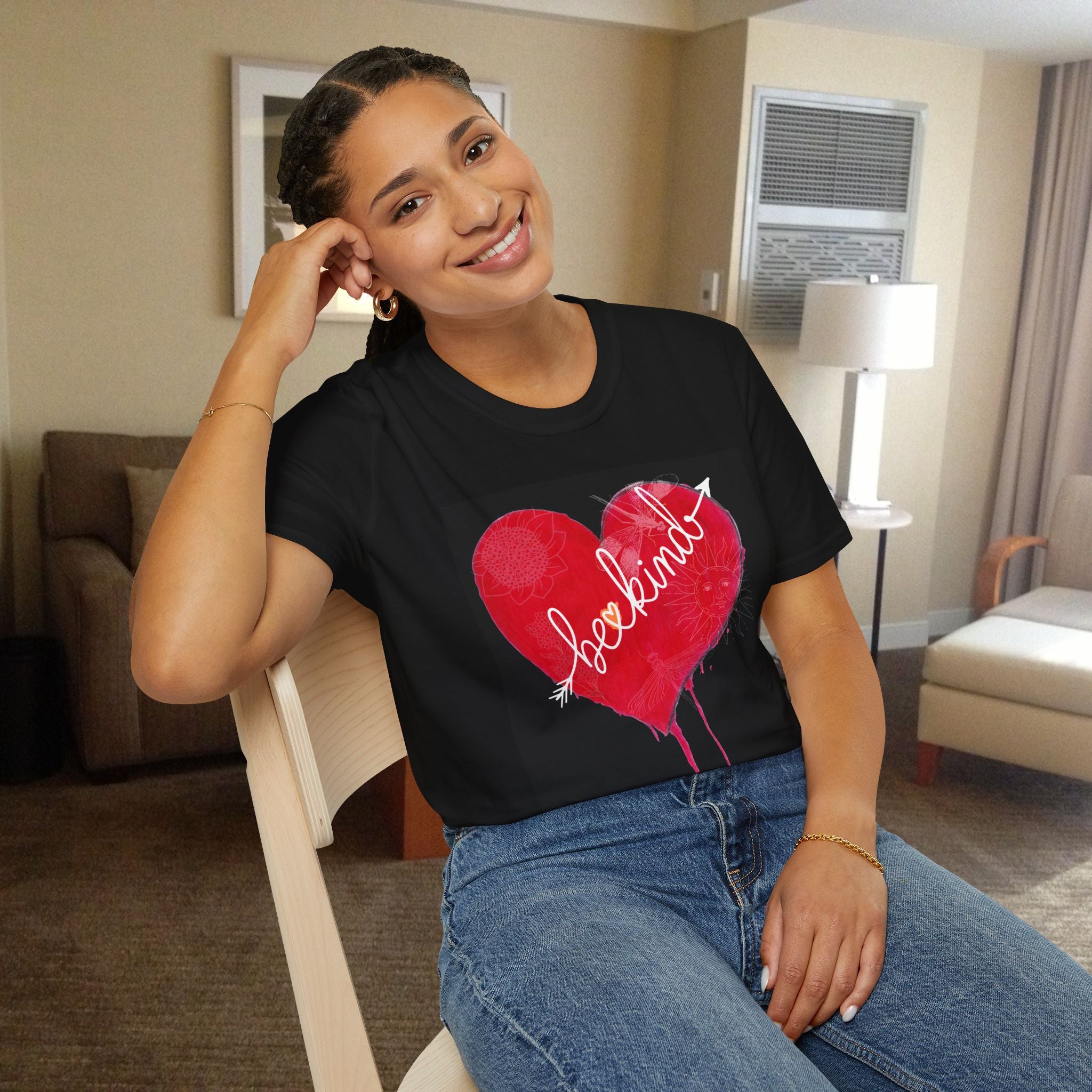 Woman wearing a black t-shirt with a red heart design sitting in a room.