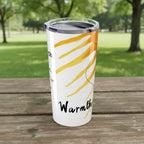 Tumbler with sun design and 'warmth' text on a park picnic table