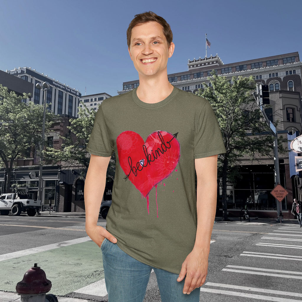 Person wearing a green t-shirt with a red heart graphic and text, standing on a city street.