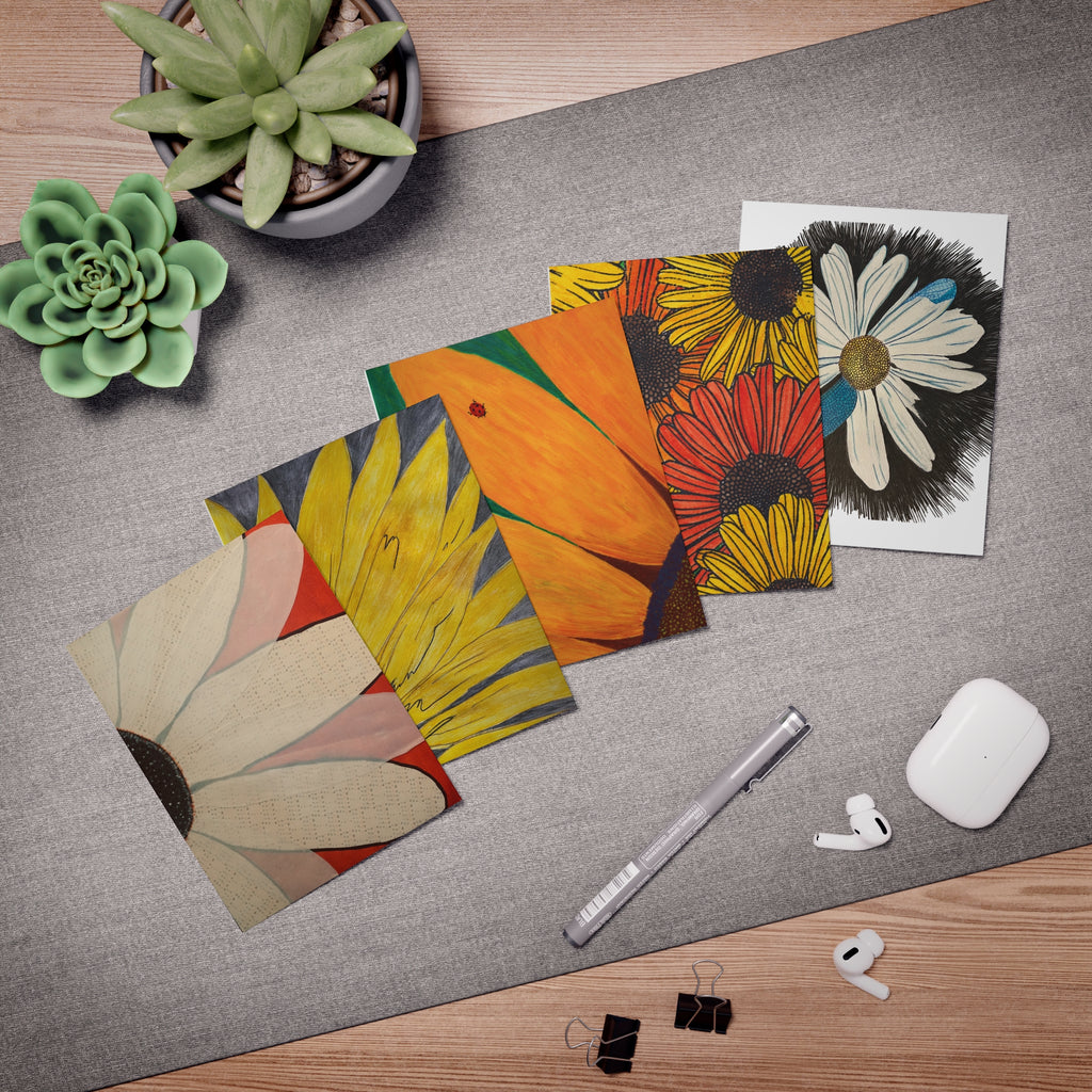 5 greeting cards with different floral design on a desk with pen, succulent, earbugd and binder clips