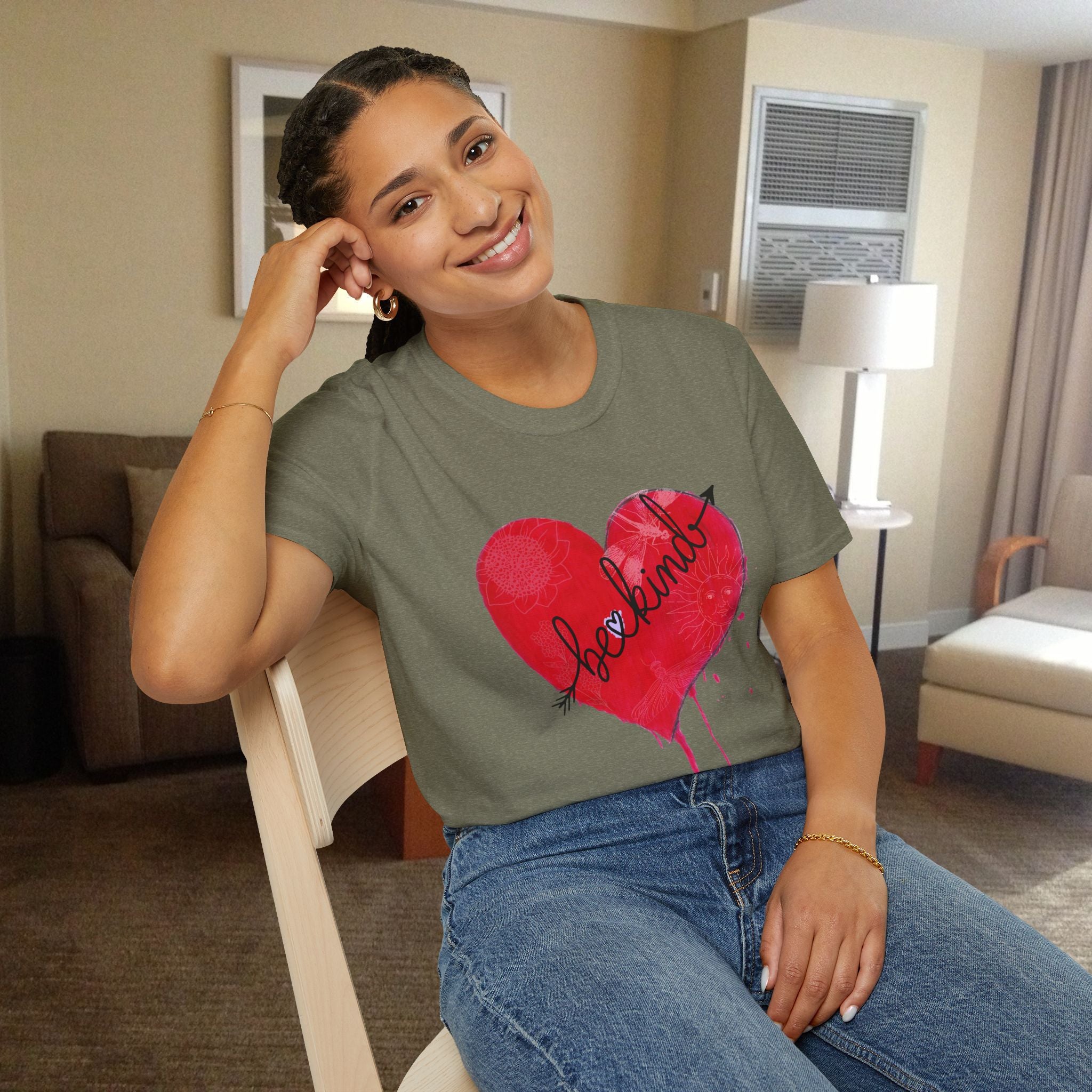 Woman wearing a green t-shirt with a red heart design in a room.