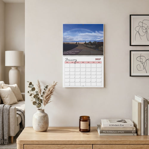 January 2027 Lava Beds National Monument wall calendar on wall above a desk with books