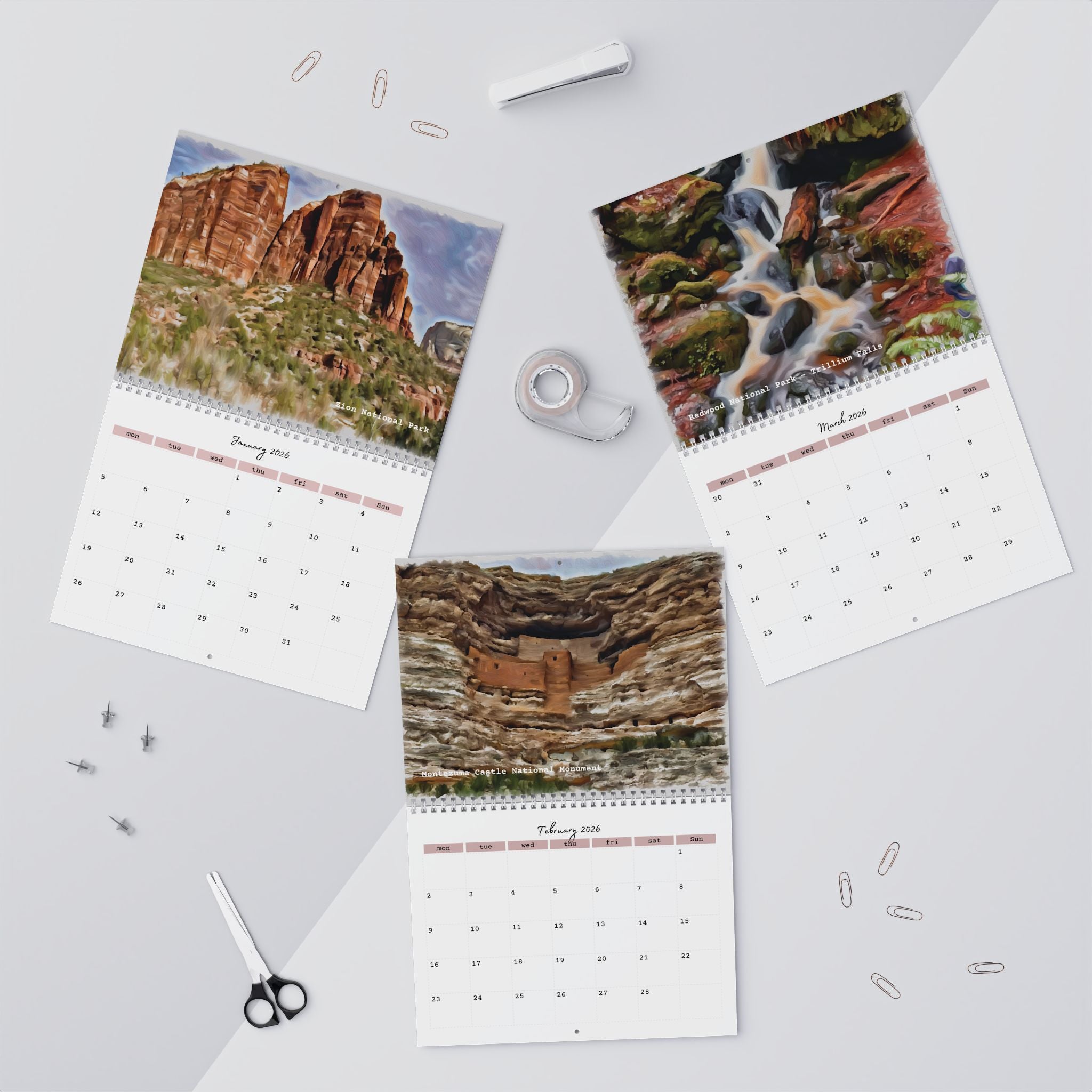 Calendar with scenic landscapes on a light gray surface with office supplies.