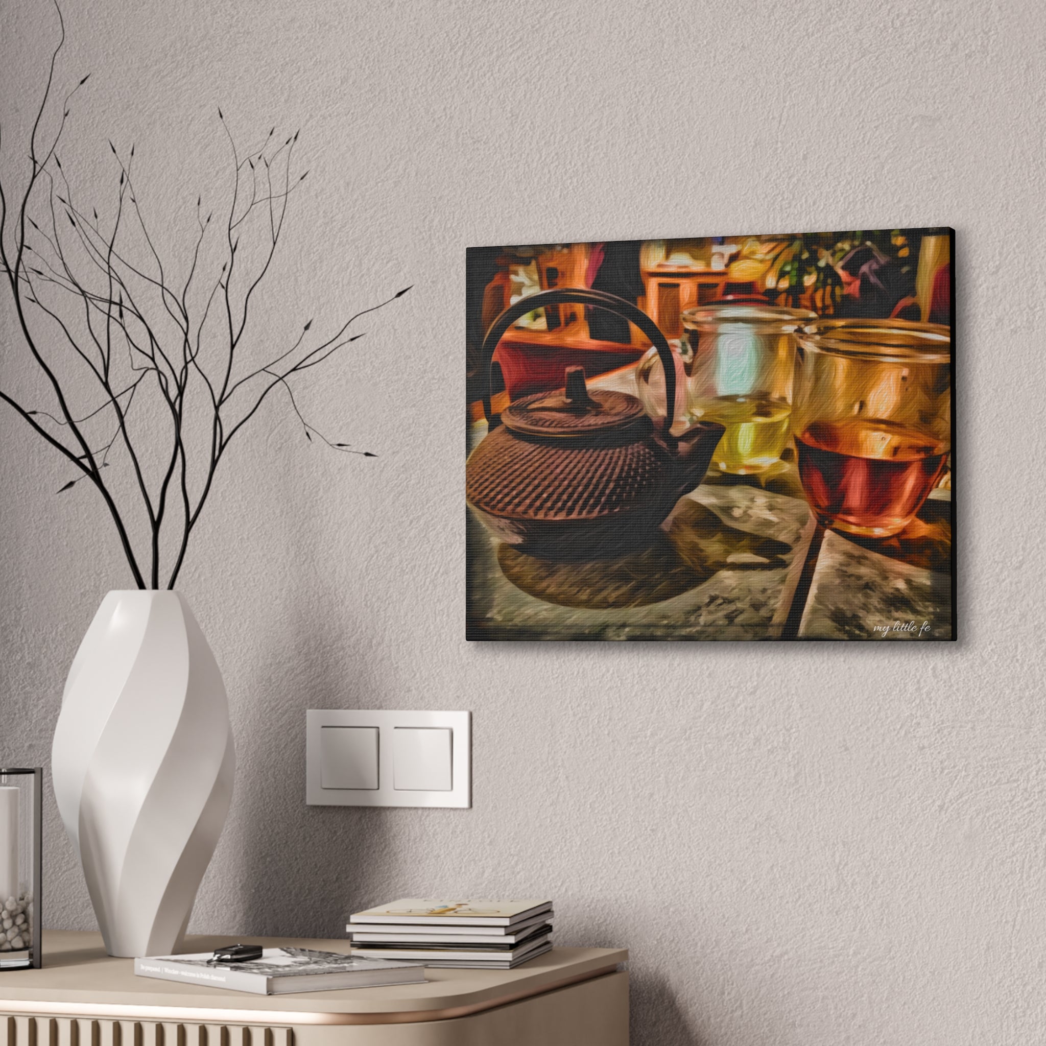 Framed artwork of a teapot and glasses on a wall above a desk with decorative items.