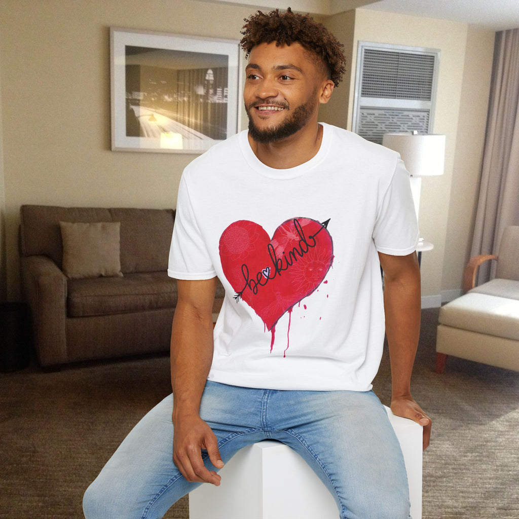 Man wearing a white t-shirt with a red heart design sitting in a living room.
