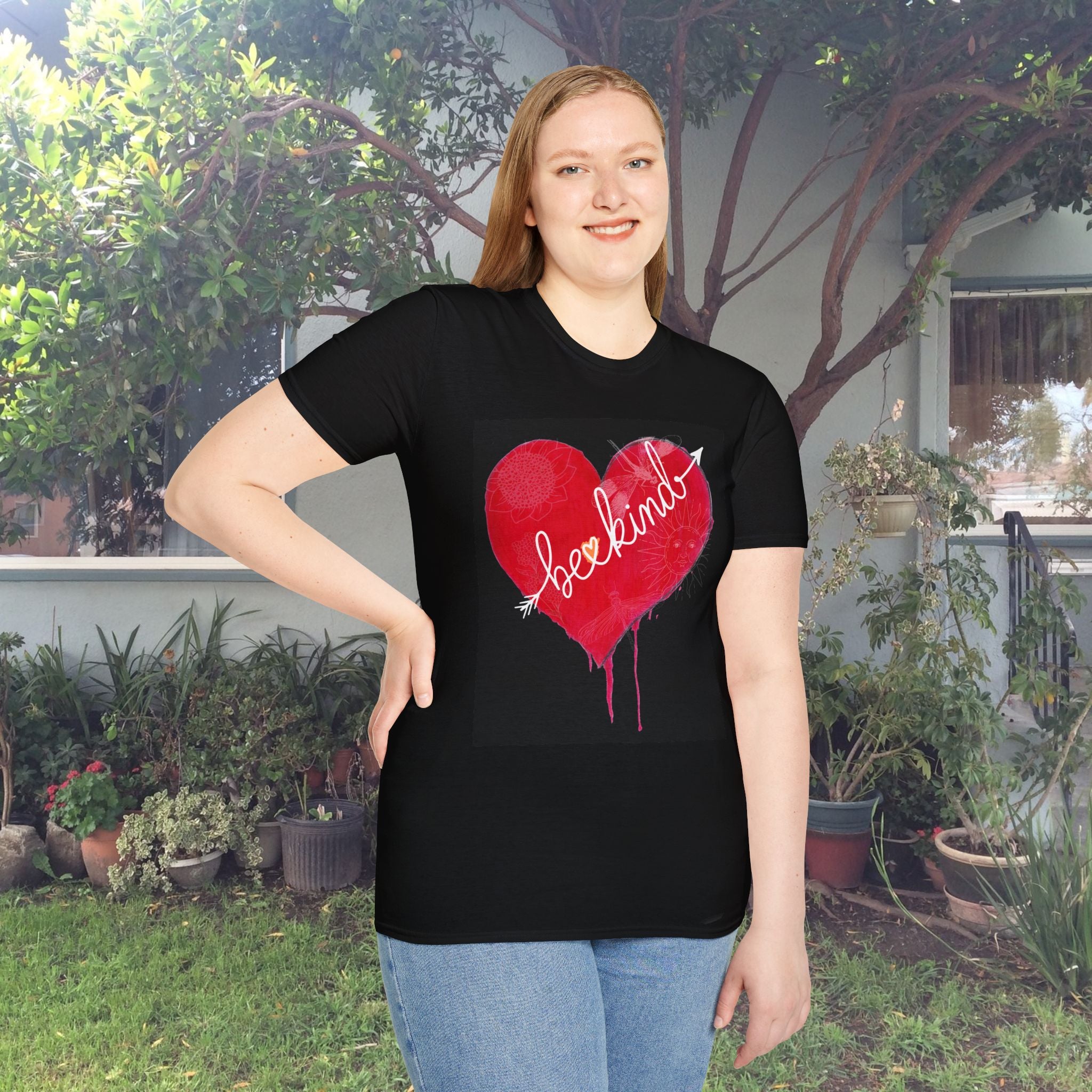 Person wearing a black t-shirt with a red heart design outdoors.