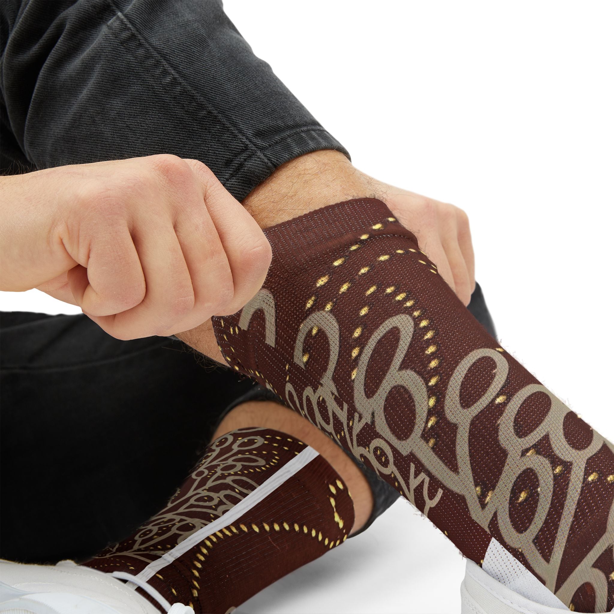 Person wearing brown and beige patterned compression sleeves on their arm.
