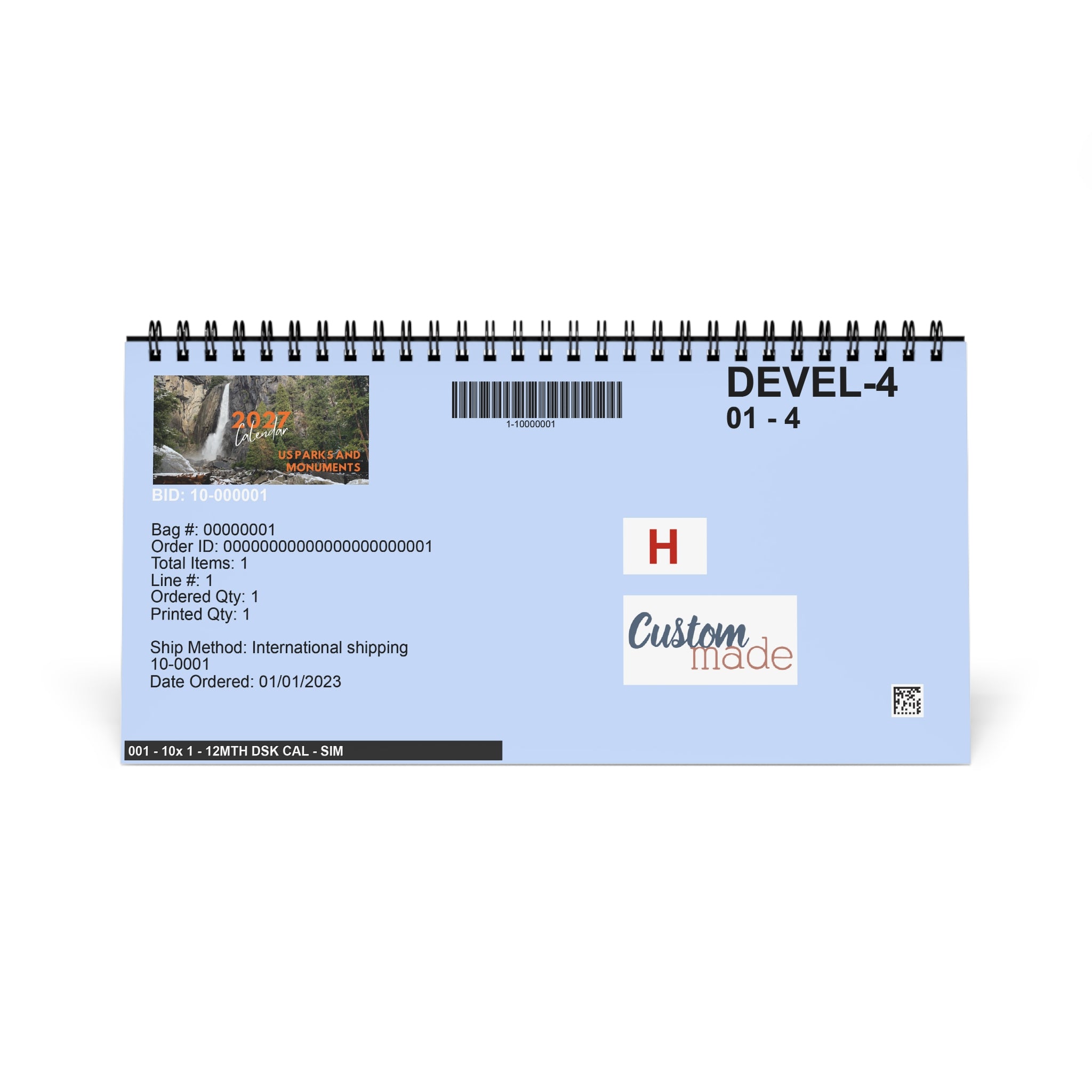 A spiral-bound desk calendar or planner page with a light blue background, black text reading 'DEVEL-4 01-4', a barcode, and sample order details. The design includes a small waterfall photo, a red 'H', and 'Custom trade' branding.