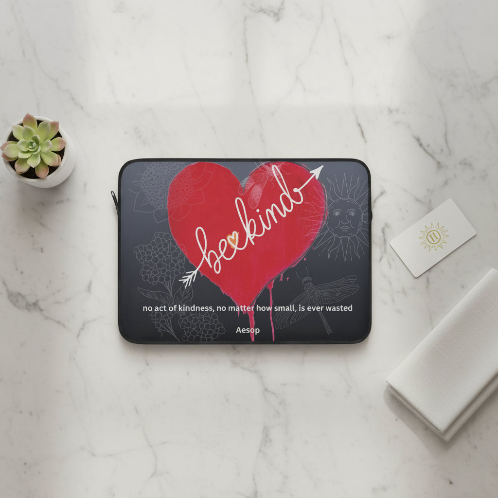 Laptop sleeve with a red heart and 'be kind' text on marble table