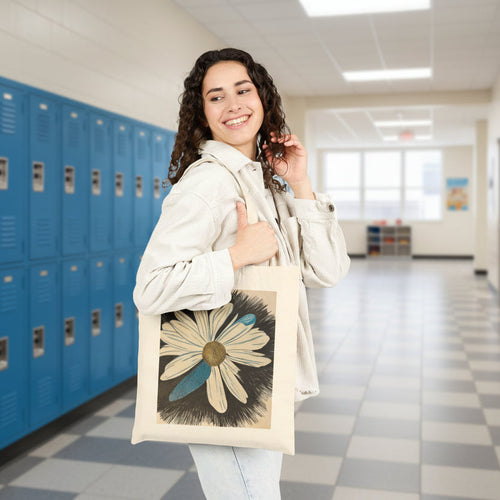 Woman holding a tote bag with a daisy dragonfly wings design on a school setting