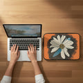 Hands working on a laptop with a dasiy dragonfly wings laptop case next to it designed by Marife Rosales of MyLittleFe.
