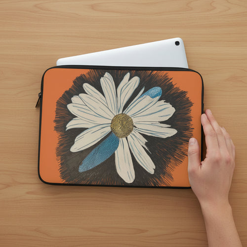 Laptop sleeve with daisy dragonfly wings on orange background on a wood table with an ipad inside and hand next to it.