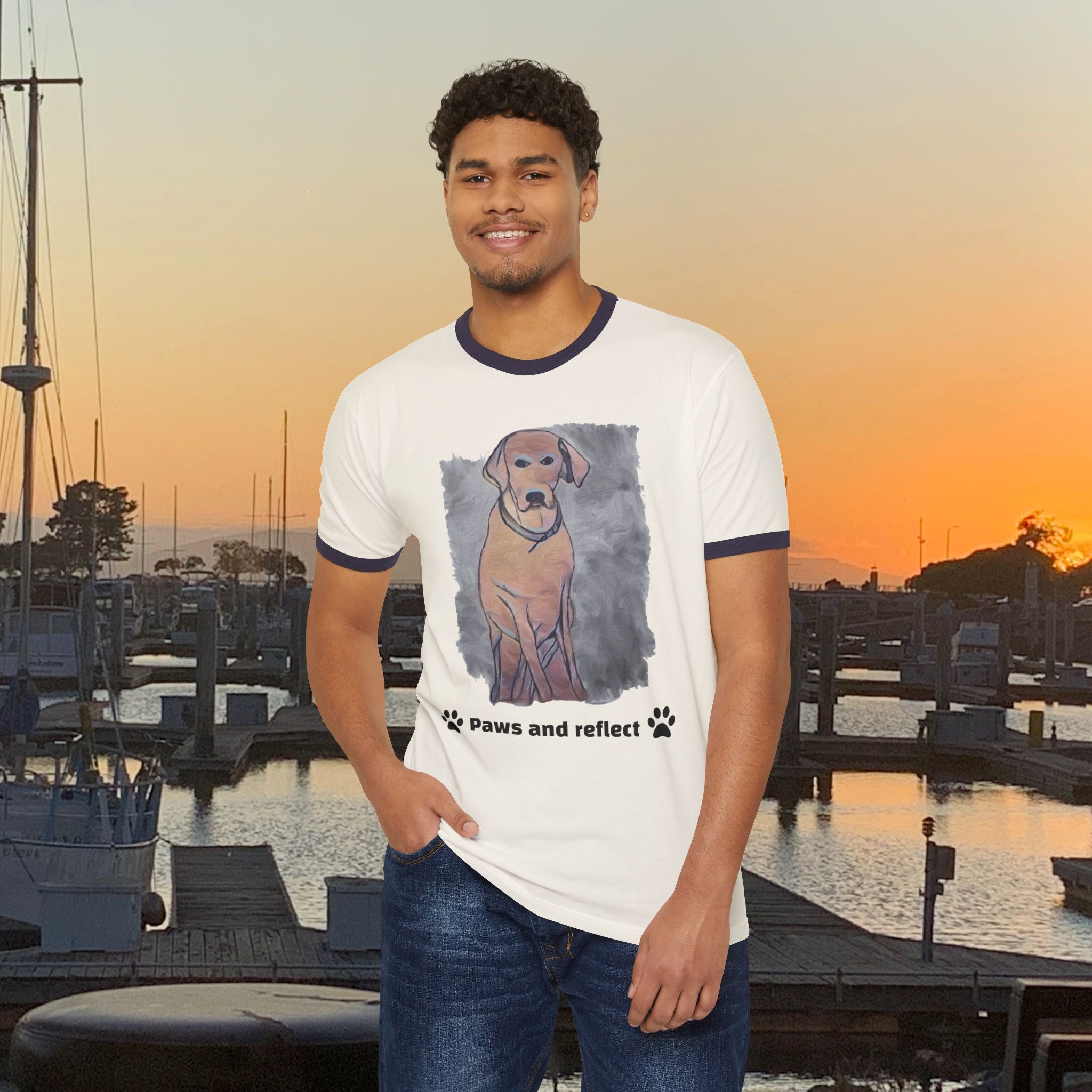 Man wearing a t-shirt with a dog graphic and text at a marina during sunset.