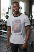 Man wearing a shirt with dog illustration and text that says paws and reflect in a gym setting