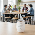 White Tumbler with Dragonfly stick drawing in an office lunch room with people eating in the background.