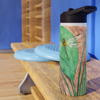Water bottle with dragonfly design on a wooden bench against a blue wall.