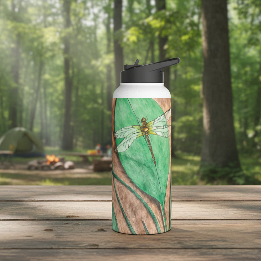 Water bottle with dragonfly on a leaf design on top a picnic table at a campground
