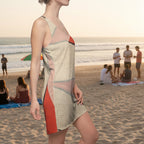 Woman wearing a sleeveless dress Flower collage petals on red background a a beach