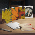 Set of floral greeting cards on a wooden surface with a pen.