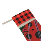 Close-up of the red-and-black plaid cuff, stitching, hanging loop, and printed ladybug artwork