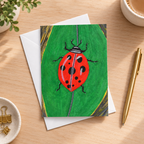 A painted ladybug on a green leaf, with a red body, black spots and legs, and a textured background.