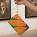 Clutch bag with a ladybug on a sunflower design held by a woman's hand at a museum
