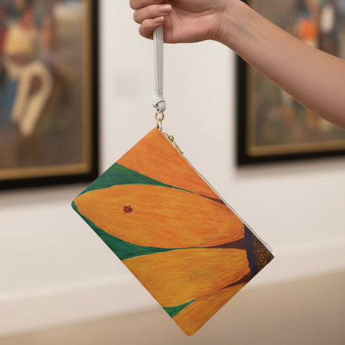 Clutch bag with a ladybug on a sunflower design held by a woman's hand at a museum